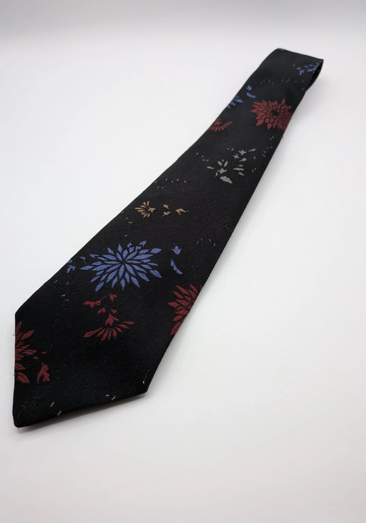 Uomo black tie with red and blue floral pattern, "Misto Seta" label, Made in Italy.