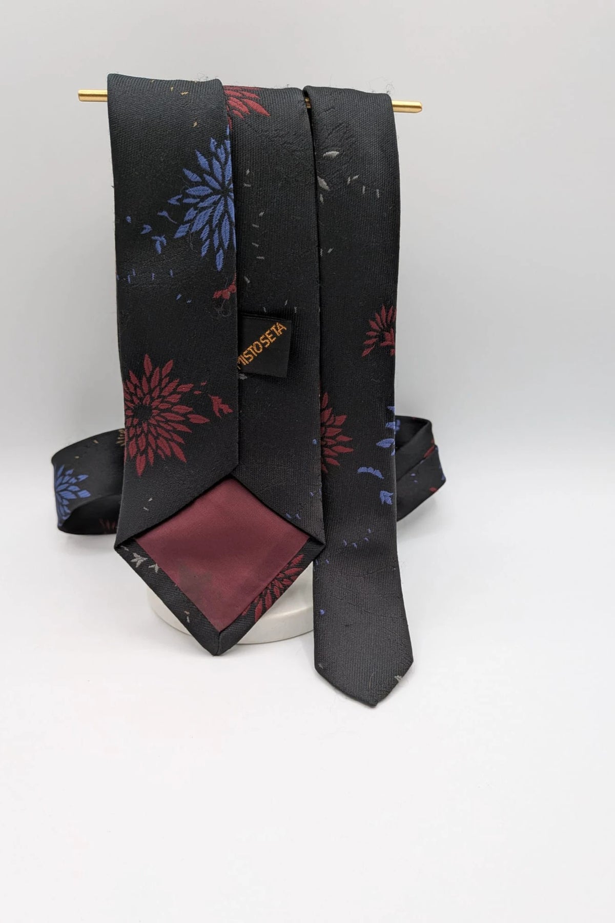 Uomo black tie with red and blue floral pattern, "Misto Seta" label, Made in Italy.