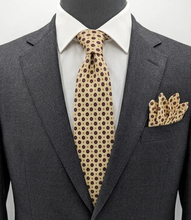 Uomo beige tie with floral pattern, blue and red flowers, geometric ochre details.