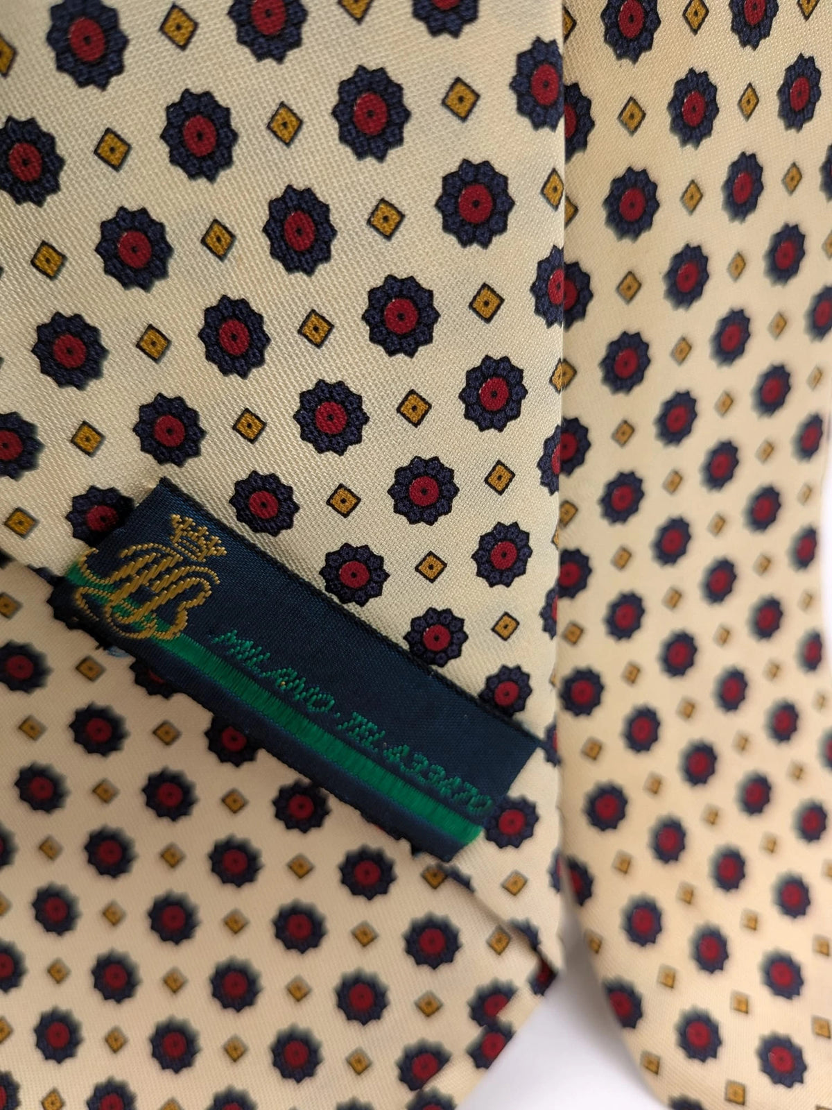 Uomo beige tie with floral pattern, blue and red flowers, geometric ochre details.