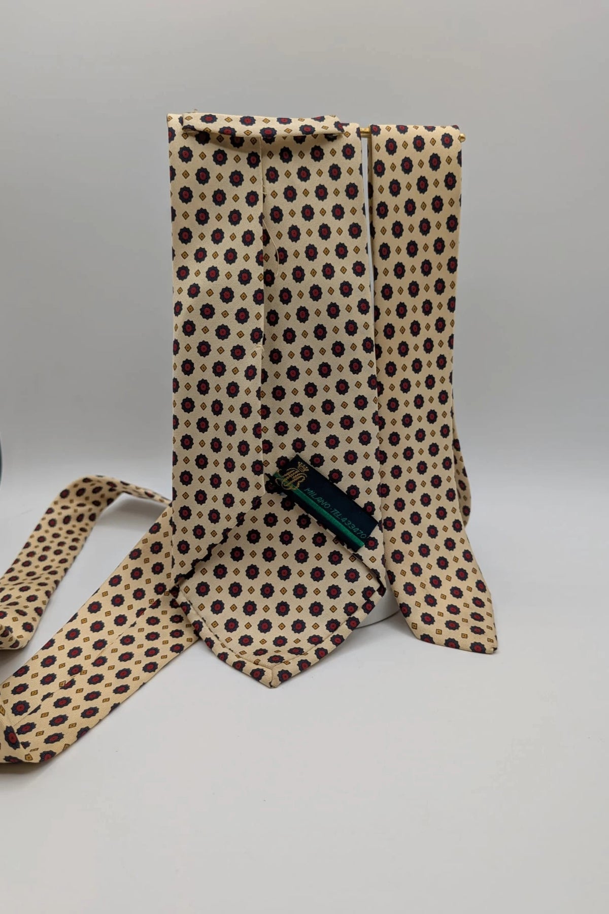 Uomo beige tie with floral pattern, blue and red flowers, geometric ochre details.