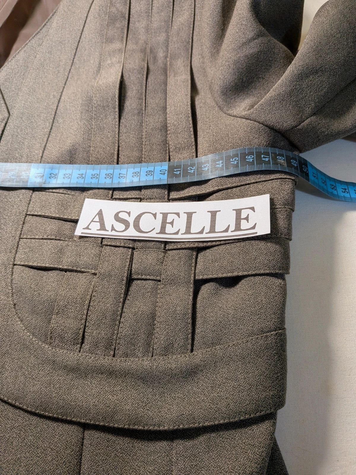 M-Made in Italy grey skirt suit with pleated jacket and decorative buttons.