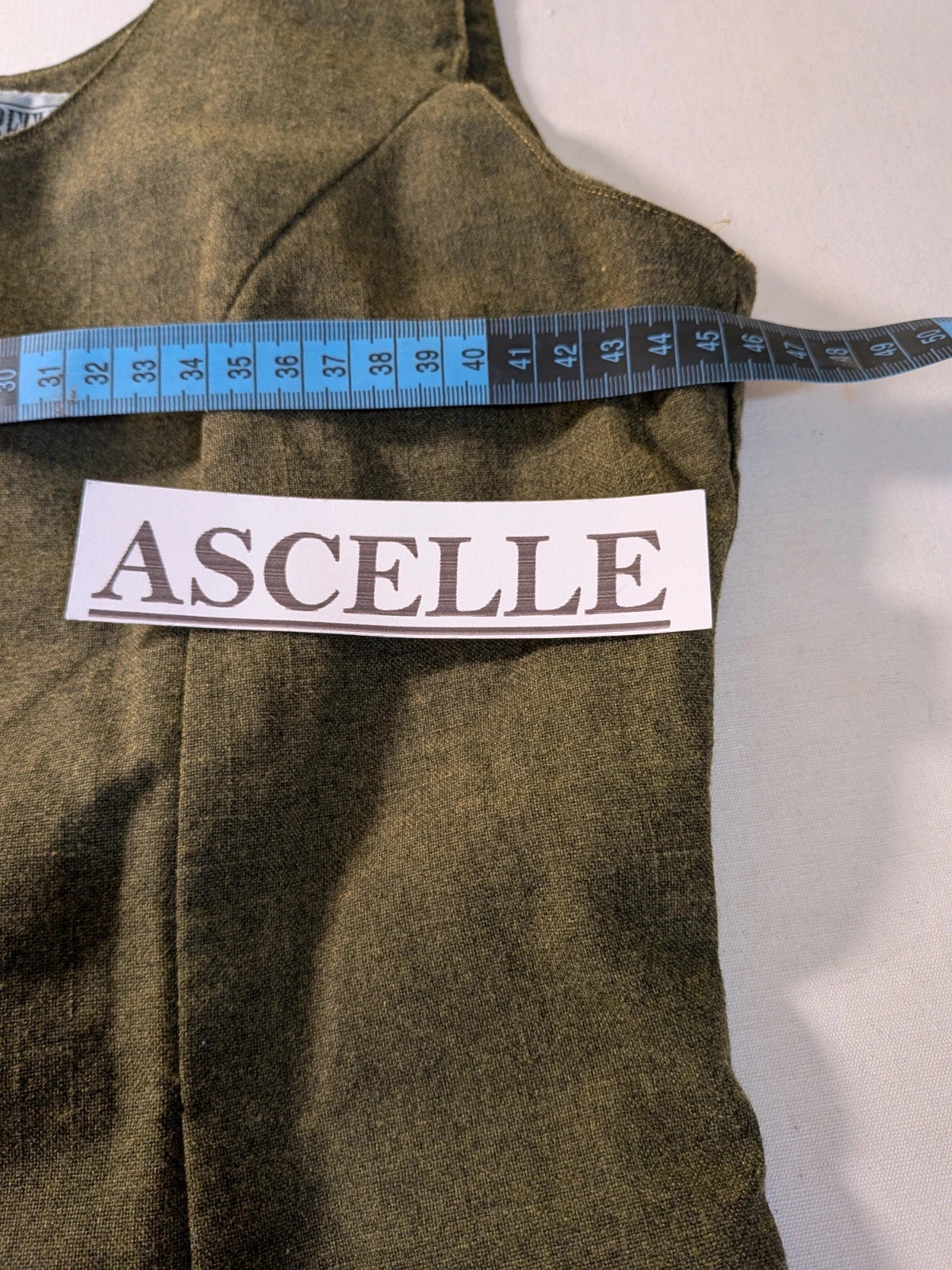 Oliva khaki skirt suit Freeling with textured fabric, short sleeve jacket, and sleeveless dress.