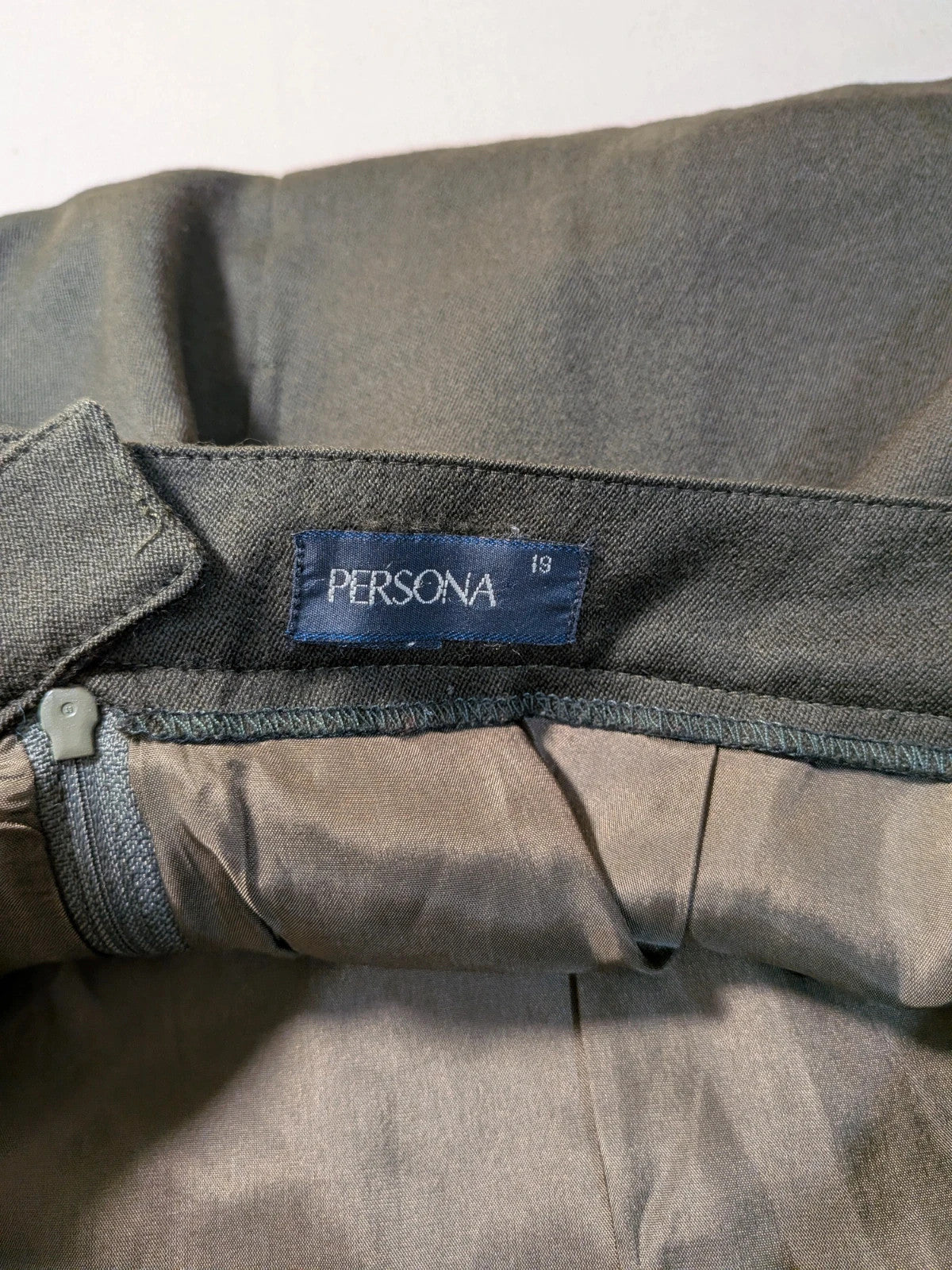 Persona green skirt suit with structured long-sleeve jacket and front buttons, 100% virgin wool.