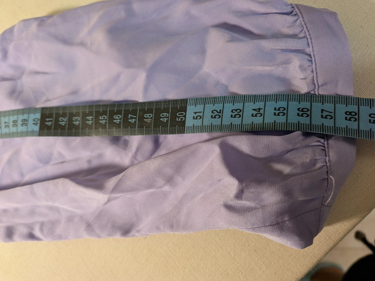 Index purple blouse with bow collar and long sleeves, paired with navy tailored pants.