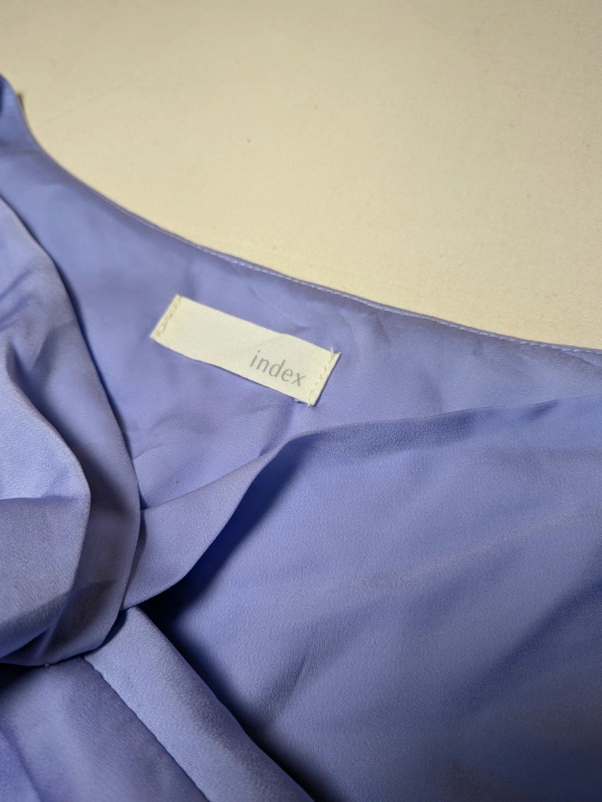 Index purple blouse with bow collar and long sleeves, paired with navy tailored pants.