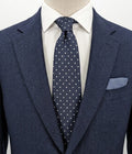 Uomo navy necktie with jacquard polka dot pattern and classic pointed style.
